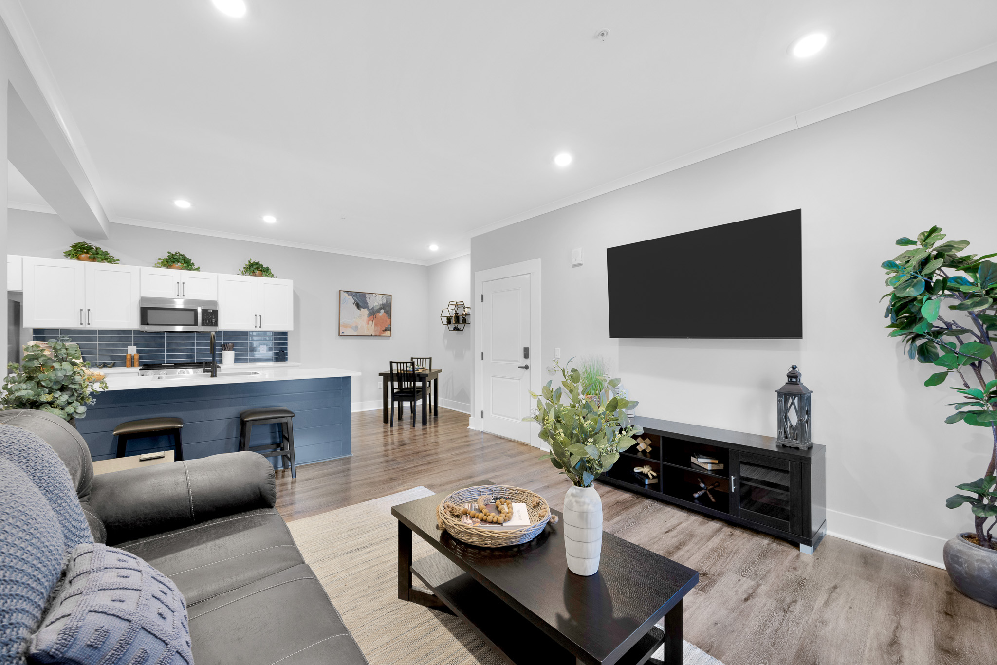 a person in yellow gloves using a squeegee to clean a large window in a living room, bright and airy, professional cleaning service photo